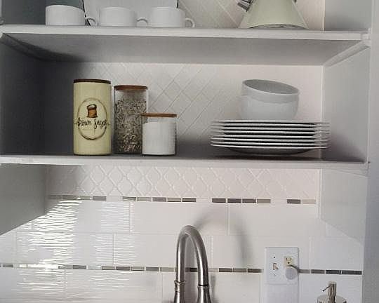 Corian sink, pull-down, single-handle faucet, display/store shelves above sink.