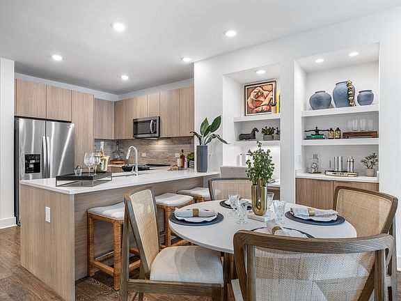Modern kitchen with sleek cabinetry, stainless steel appliances, and a cozy dining area, ideal for entertaining.
