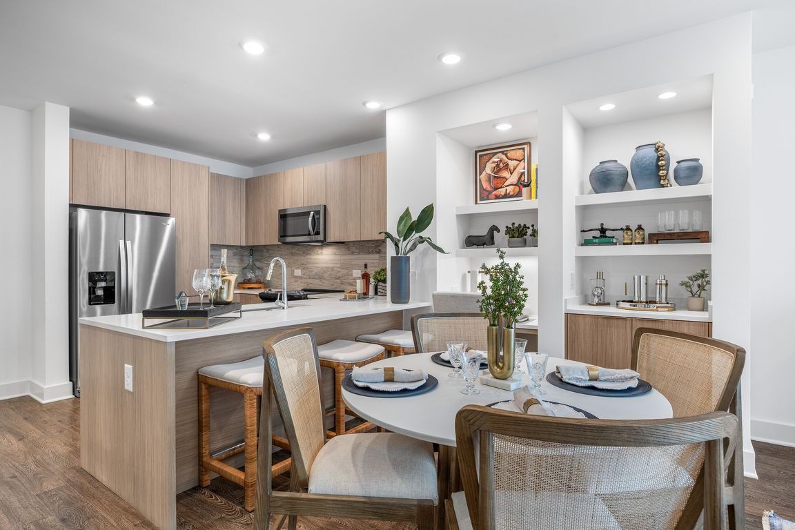 Modern kitchen with sleek cabinetry, stainless steel appliances, and a cozy dining area, ideal for entertaining.