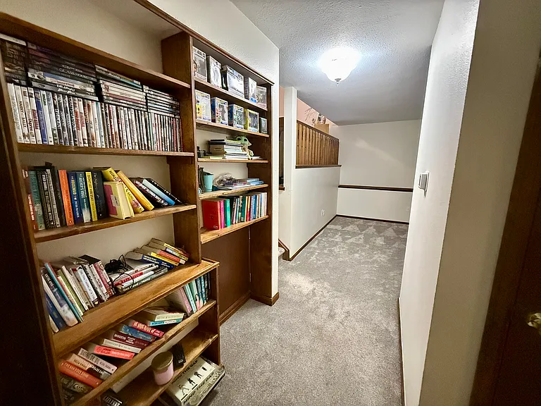 Downstairs hallway- built in library shelves, small door to crawl space