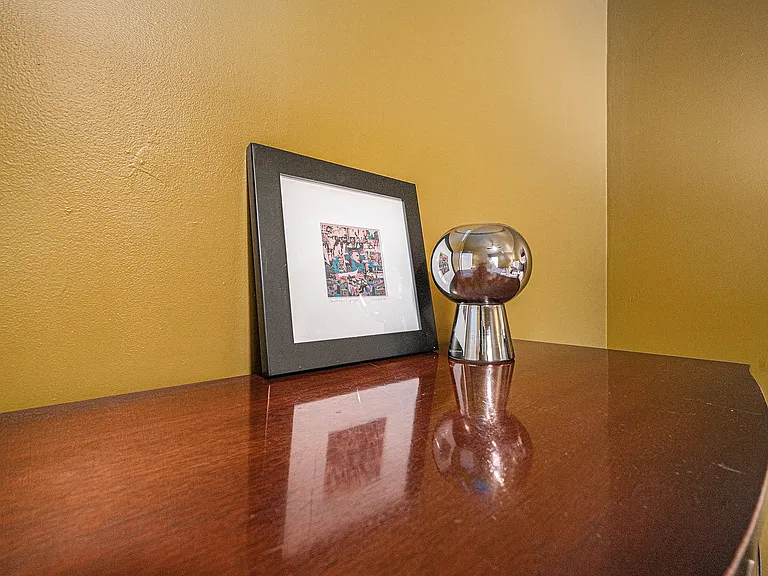 Decorative elements on the cabinet, including a painting and curated display, bring charm and a cozy, polished feel to the space.