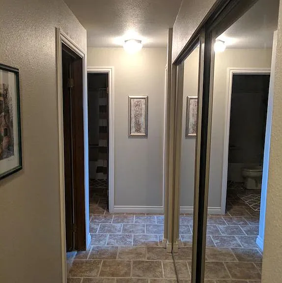Hallway with storage on right hand side (sliding glass doors). Bedroom #1 entrance is on the left, bathroom #1 is at end of hall. Bedroom #2 entrance is at end of hall on right.