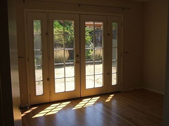 French doors in master bedroom overlook landscaped backyard