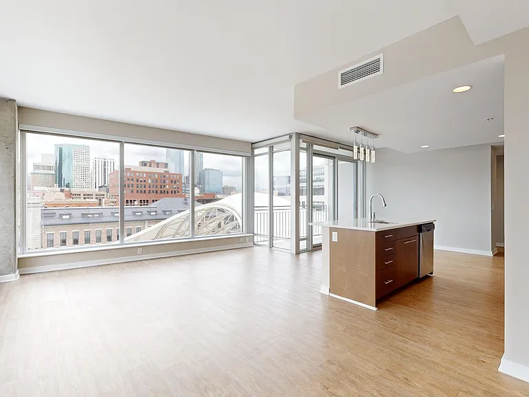 Apartment dining and living room with wood-style flooring.
