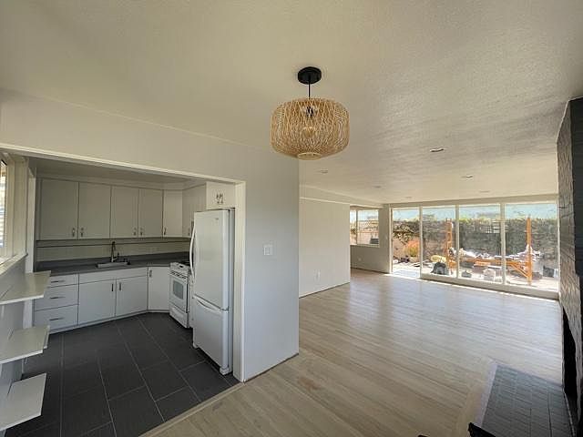 View of Front Room and Kitchen from Dining area (please excuse the scaffolding outside the windows).