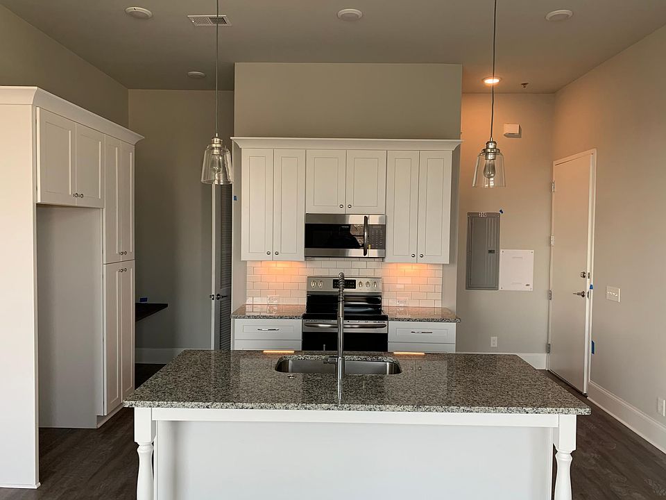 Nicely appointed kitchen with granite countertops, shaker cabinets, and stainless steel appliances.
