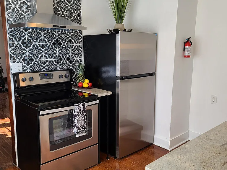 Kitchen with new Granite Countertops with Original Metal Cabinets, Stainless Steel Appliances, and Custom Tile Backsplash