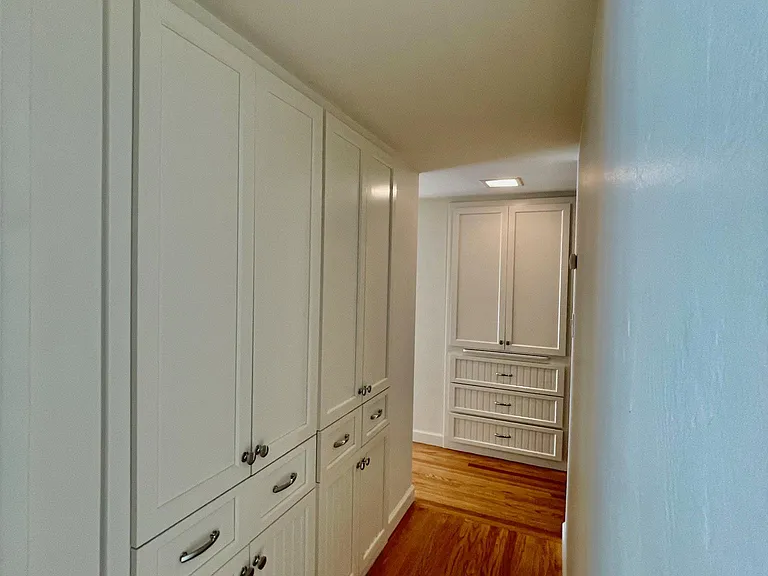 Hallway with generous built-in storage cabinets and drawers