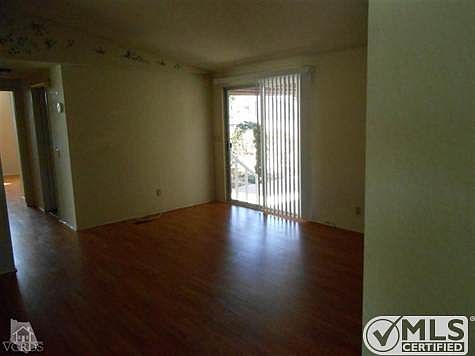 Family room with laminate floors looking down the hall to the master bedroom.  Slider is to the back yard.