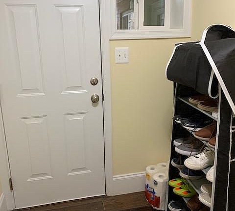 Bottom floor entrance in back shown with shoe rack.