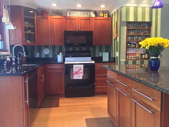 Kitchen with built-in spice rack. (Fridge, Stove/Range, Microwave with Vent Hood, Sink with Garbage Disposal, & Dishwasher.