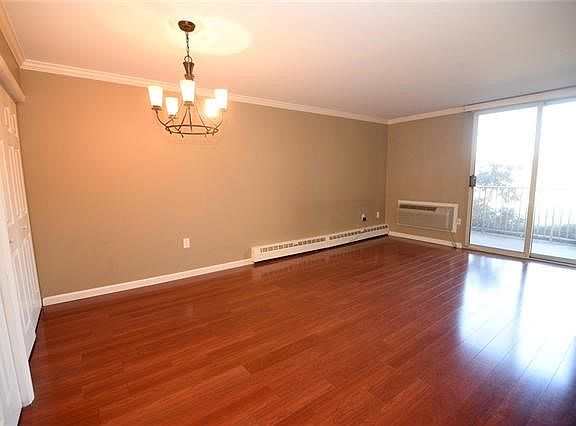 VIew of the living/dining area with slider to private balcony with seasonal view of the Hudson river.
