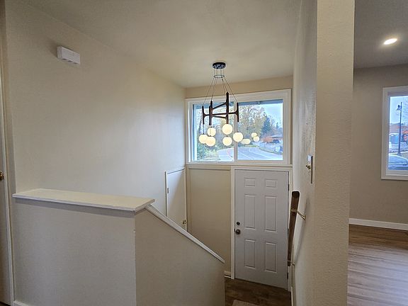 Bright entry way with modern light fixture. Coat closet.