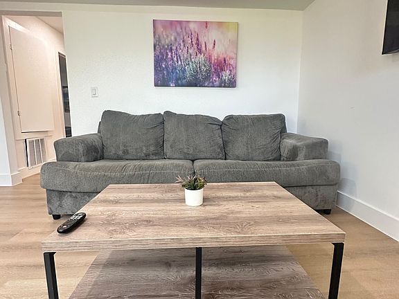 Comfortable living area with a plush sofa, coffee table, and wall-mounted TVideal for relaxing or entertaining.