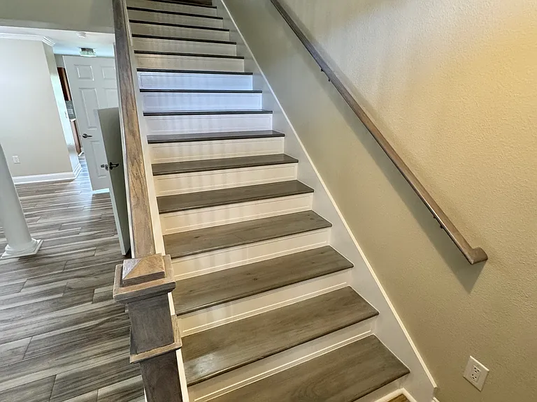 Entryway with wooden stairs leading to the second floor.