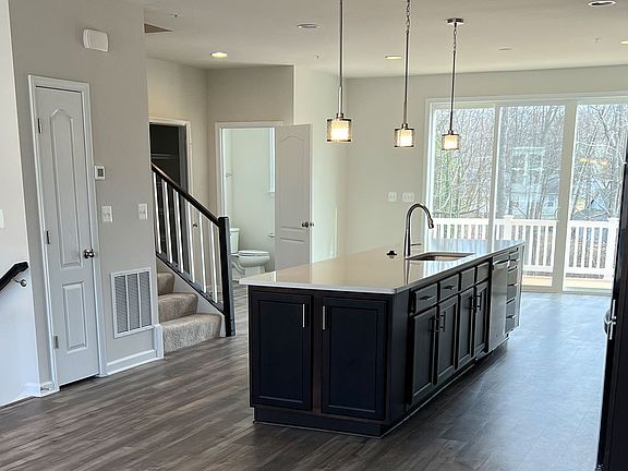 Open main floor with wood floors and center kitchen in a DRB Homes Grable II plan at the WestRidge c