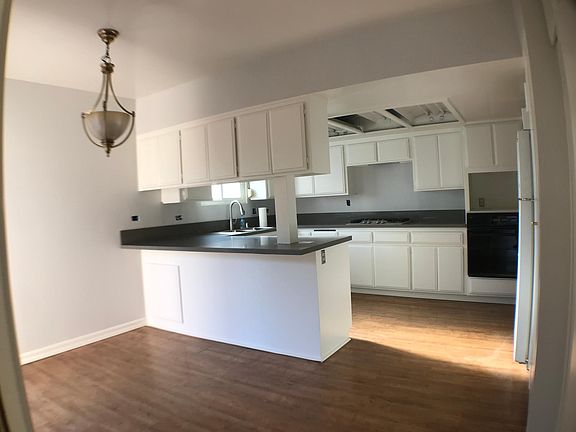 Kitchen w/ new quartz countertops, new stainless steel stovetop and sink. Bar top seating.