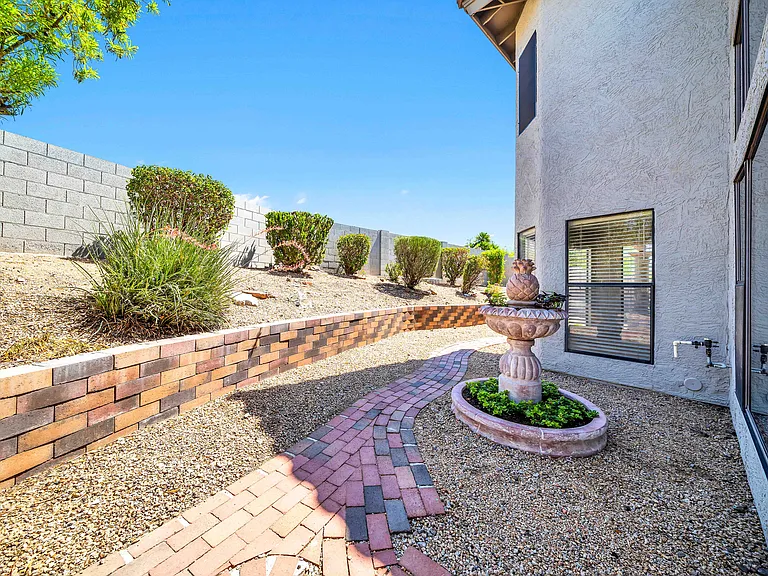Garden fountain and backyard with lush landscaping. Monthly landscaping is included in the monthly rent.