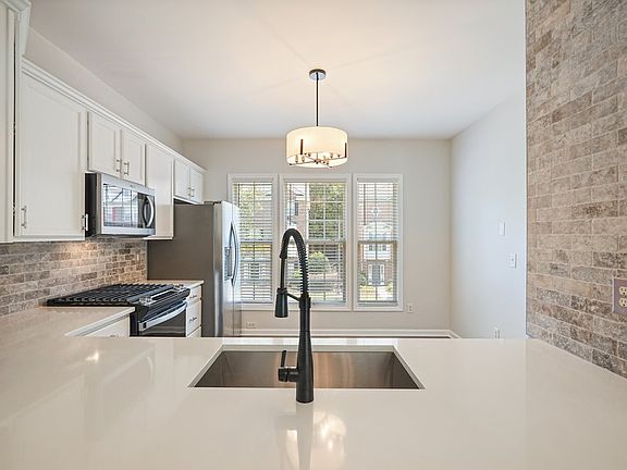Kitchen Feature Wall with Tumbled Travertine, Sink and Quartz Countertop Bar