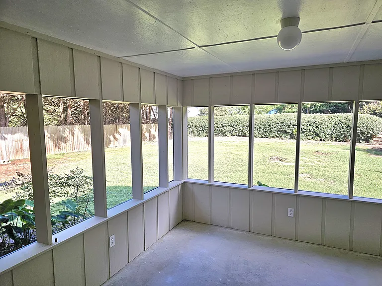 Screened 11 1/2' x 23' patio with view of large fenced backyard.