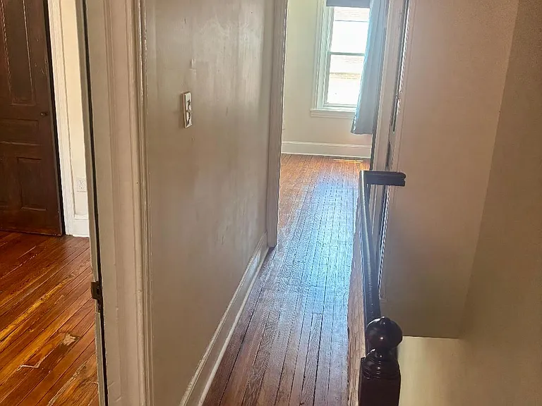 Top of stairs looking toward front bedroom with second bedroom on left