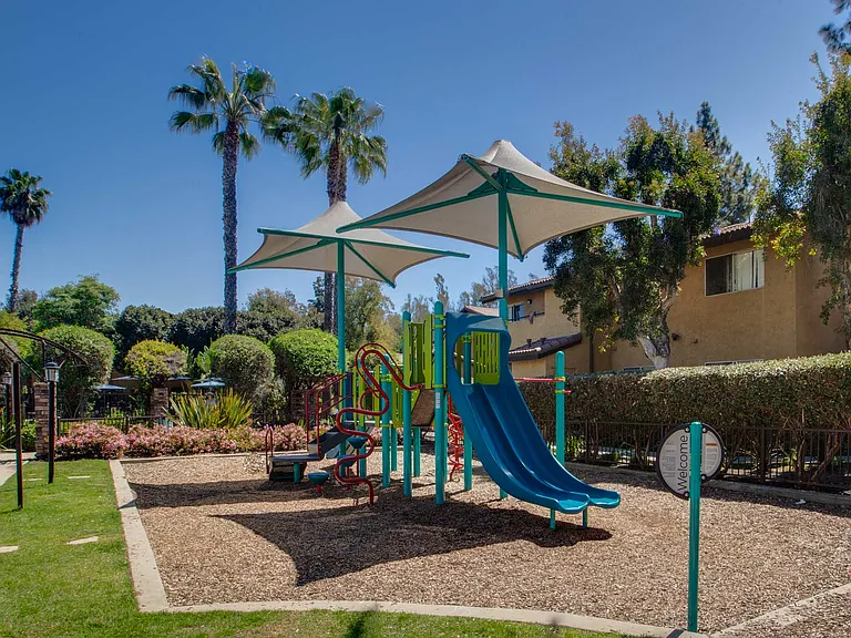 Sandy playground area includes a slide