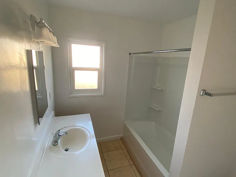Bathroom sink and shower with natural lighting at Edison Apartments in Burbank, California.