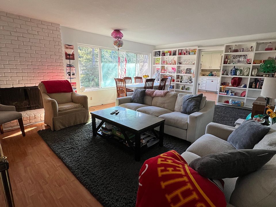 Huge living room with cozy fireplace, built-in bookshelves, sunny large window