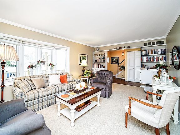 Bright and spacious living room with replacement bow window and custom built-ins.