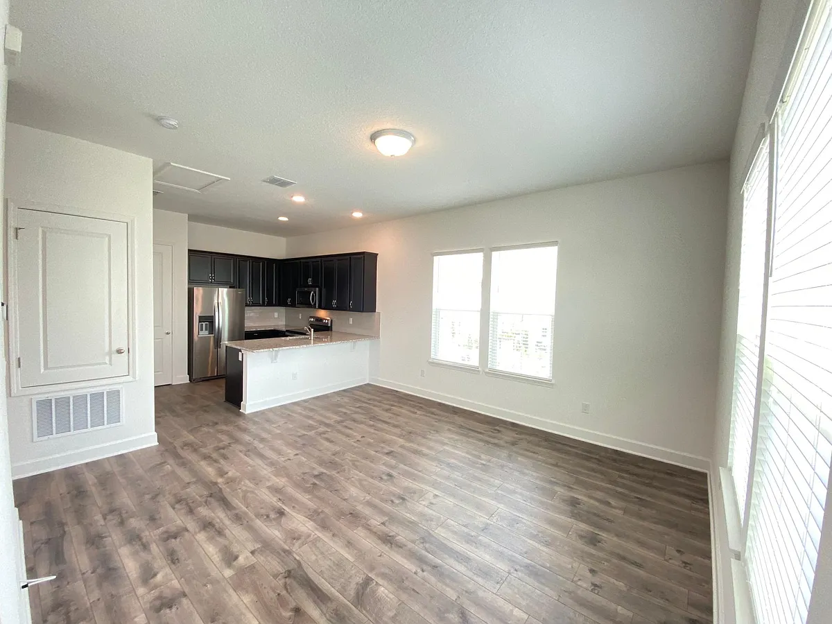 The view after going up the stairs. Family room with the kitchen in the background. - 13706 Rosbash Aly