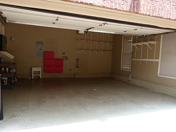 Interior of 2 car garage with lots of shelving and storage