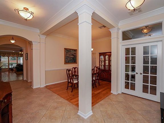 Formal dining room is flanked by pillars, elegant crown molding and chair rail