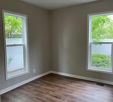 Master bedroom with large windows and private fenced-in backyard.