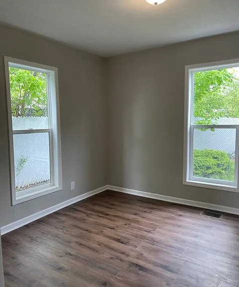 Master bedroom with large windows and private fenced-in backyard.