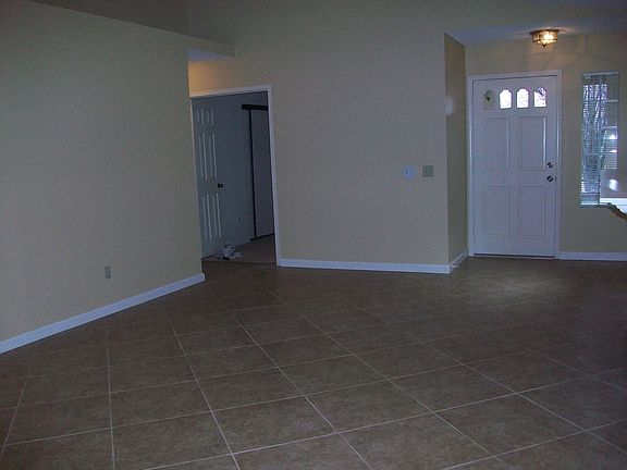 Living room, facing front door entryway and first (office) bedroom