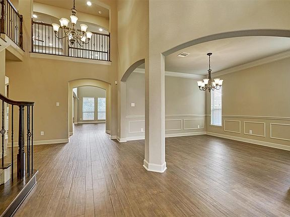 As you enter the home you are greeted with high ceiling, gorgeous wood look tile and a beautiful staircase.
