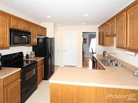 Spacious eat-in kitchen with tiled flooring, hickory cabinets, upgraded appliances including smooth top oven/range and built-in microwave.  Side by side refrigerator negotiable.  Peninsula counter, deep pantry and walkout to patio are also included in the kitchen.