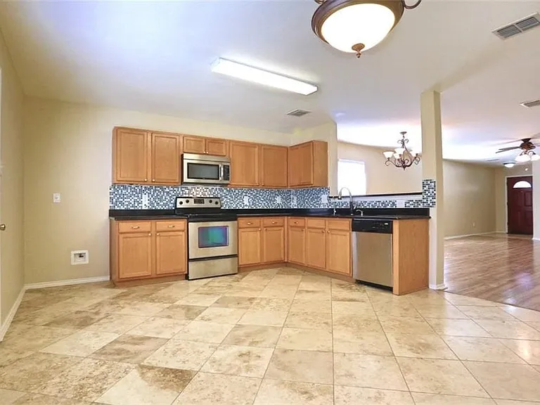 View of kitchen plenty of upper cabinets and counter space.