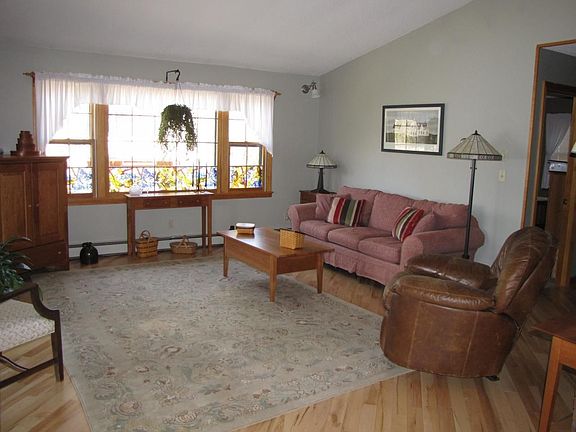 Spacious living room leads to enclosed porch and offers views of the lake