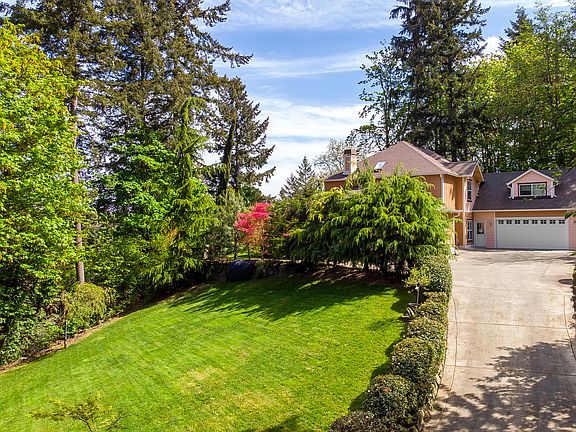 A sunny knoll top setting with beautiful mature landscaping and lawns.