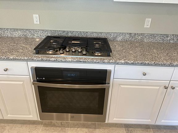Five-burner gas range and all appliances are GE stainless steel.