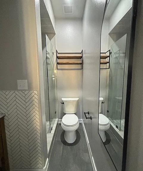 Towel rack and shelves above the toilet.