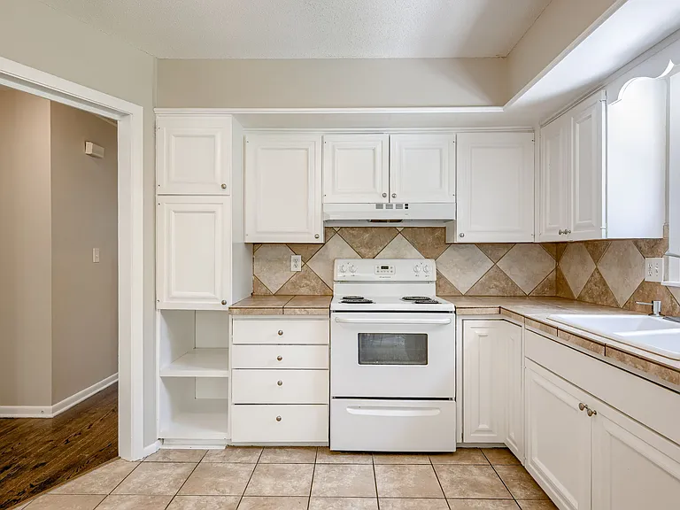 Kitchen with easy clean / low maintenaince tile counters, backsplash, and flooring