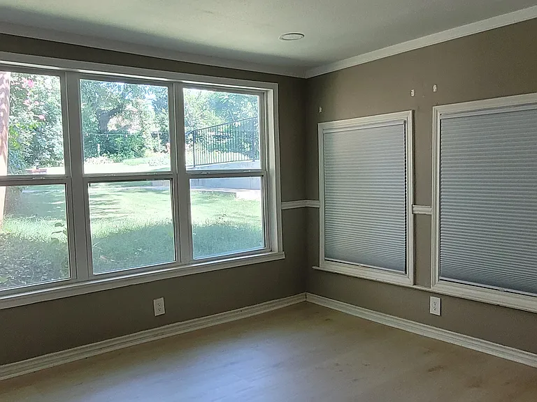 Back Room (Rm #2) with back door on right. Pool out back window. This room has been used as an office, an additional bedroom, and a dining room. Brand new flooring. Just changed blinds, so still need to touch up paint above windows. More pics to come.