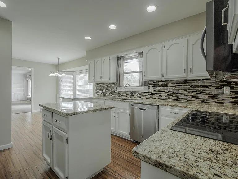 Beautiful granite countertops and attractive backsplash. Eat-in kitchen dining with views of the backyard. VINYL FLOORING BEING REPLACED WITH GRAY TILE.