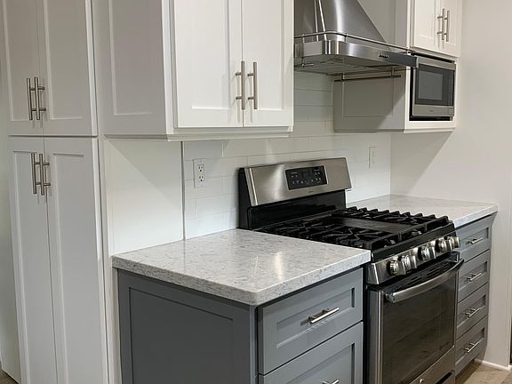 Range with hood and pantry area.