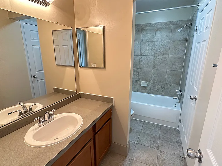 Your updated bath features a large granite countertop vanity, tile flooring and tub enclosure, and special lighting too.