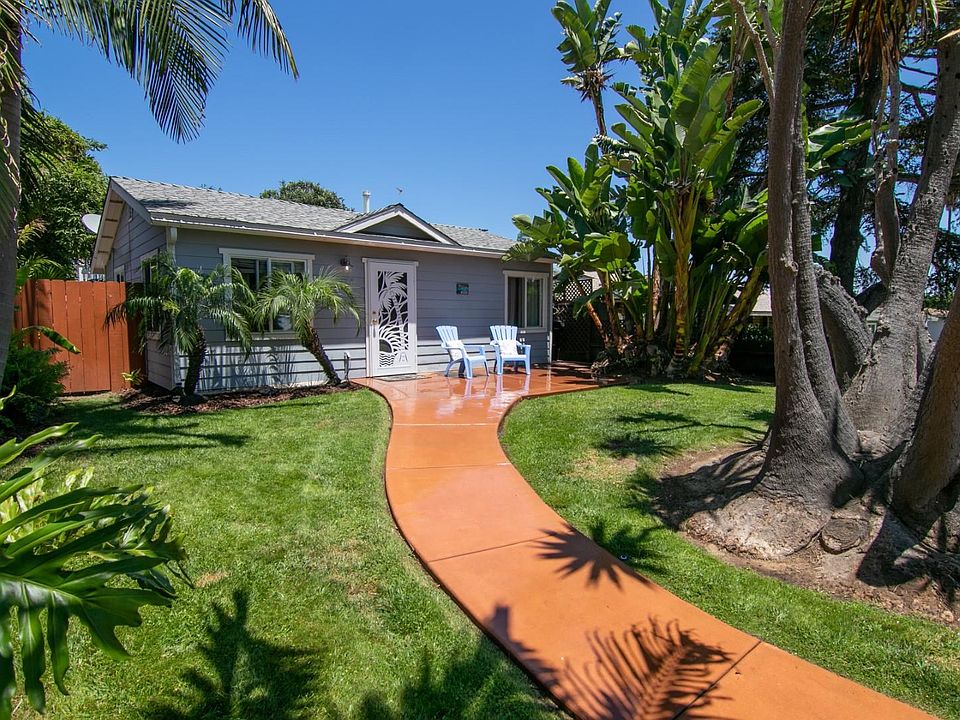 Large front yard with green grass and patio.