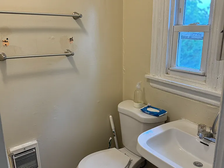 the holes in the wall have been fixed. shower is located within the bathroom to the left in the photo.