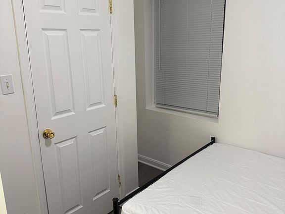 Private bedroom with a bed frame, easy-care flooring, and a window with blinds for light and privacy.